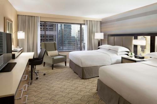 a hotel room with two beds and a television at Hilton Toronto in Toronto