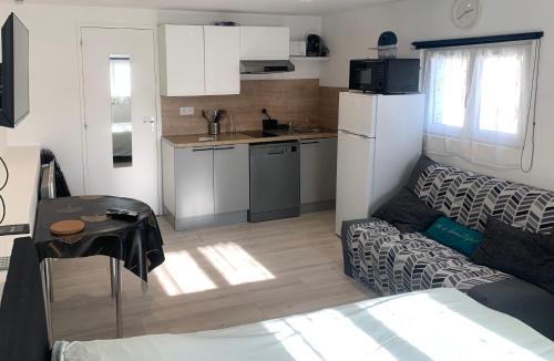un petit salon avec un canapé et une cuisine dans l'établissement L'Évasion Bayeusaine - Calme et Reposante, à Bayeux