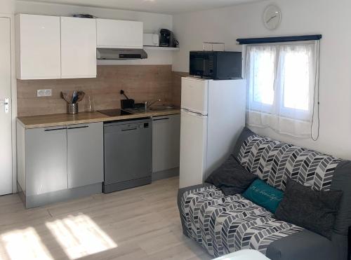 Ce petit appartement comprend une petite cuisine avec un canapé. dans l'établissement L'Évasion Bayeusaine - Calme et Reposante, à Bayeux