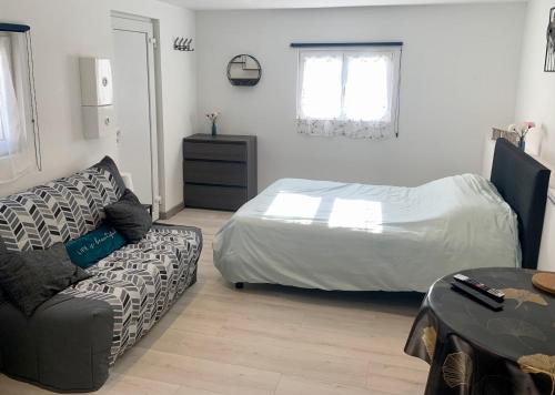 un salon avec un lit et un canapé dans l'établissement L'Évasion Bayeusaine - Calme et Reposante, à Bayeux