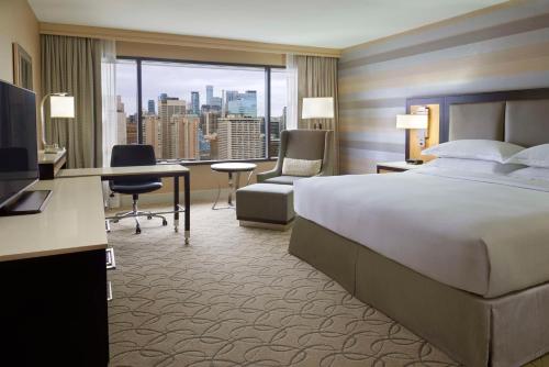 a hotel room with a bed and a desk with a computer at Hilton Toronto in Toronto