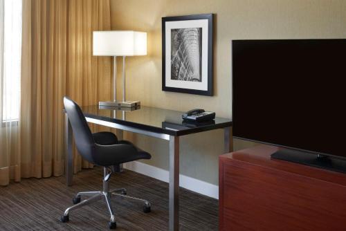 a hotel room with a desk with a chair and a television at Hilton Toronto in Toronto
