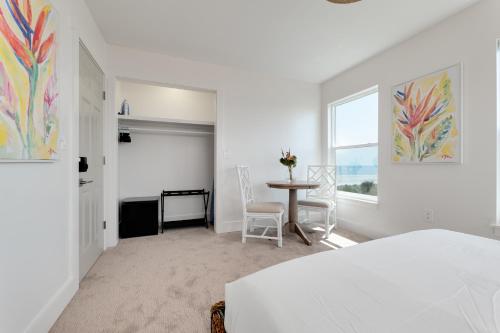 a bedroom with a bed and a table and a window at Be a Nomad - Ocean Front Boutique Hotel in Jacksonville Beach