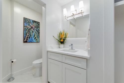 a white bathroom with a sink and a mirror at Be a Nomad - Ocean Front Boutique Hotel in Jacksonville Beach