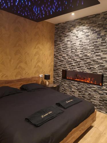 une chambre avec un lit et une cheminée dans l'établissement Appartement haut de gamme avec jacuzzi sauna à 5min de la plage à pied, au Havre