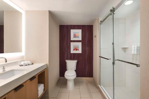 a bathroom with a toilet and a glass shower at Embassy Suites by Hilton Tampa Downtown Convention Center in Tampa