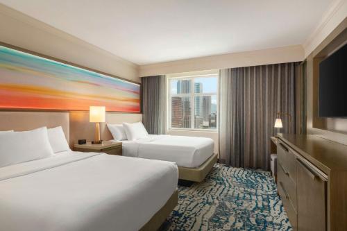 a hotel room with two beds and a large window at Embassy Suites by Hilton Tampa Downtown Convention Center in Tampa