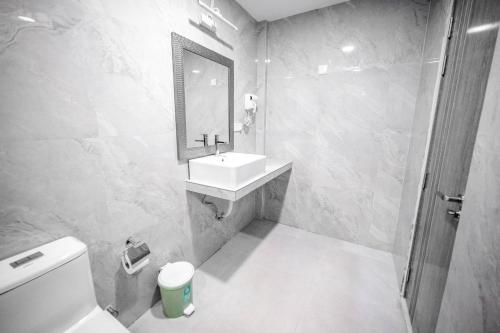 a bathroom with a sink and a toilet and a mirror at Aquatic Mathiveri in Mathiveri