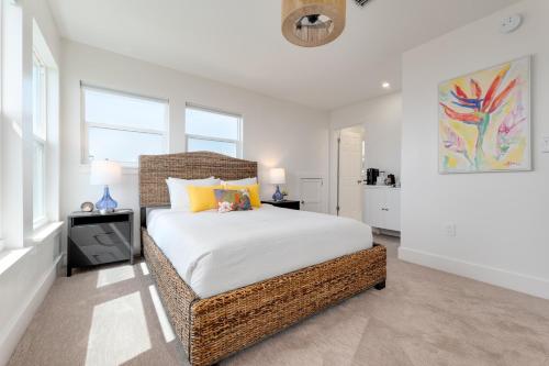 a bedroom with a bed with white sheets and yellow pillows at Be a Nomad - Ocean Front Boutique Hotel in Jacksonville Beach