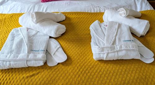 a group of towels and slippers on a bed at Charming Townhome Retreat, close to Manchester in Manchester