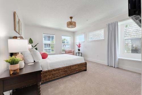a bedroom with a bed and a desk and windows at Be a Nomad - Ocean Front Boutique Hotel in Jacksonville Beach