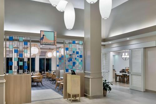 a lobby with a restaurant with tables and chairs at Hilton Garden Inn Tampa Airport/Westshore in Tampa