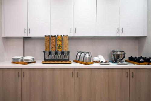 una cocina con armarios blancos y una encimera con utensilios. en Hilton Garden Inn Tampa Airport/Westshore, en Tampa