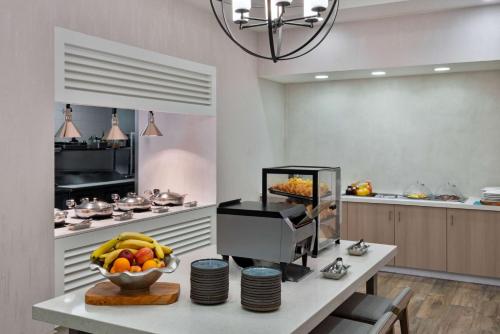 una cocina con mesa y un bol de fruta en Hilton Garden Inn Tampa Airport/Westshore, en Tampa