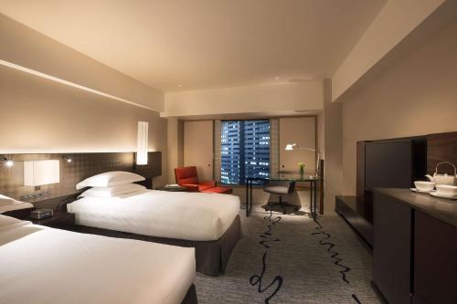 a hotel room with two beds and a desk at Hilton Tokyo Hotel in Tokyo