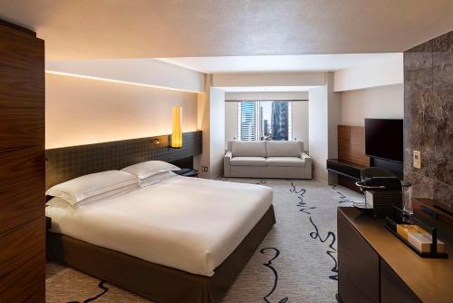 a bedroom with a large bed and a living room at Hilton Tokyo Hotel in Tokyo