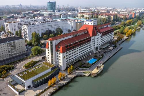 an aerial view of a city with a river and buildings at Hilton Vienna Waterfront in Vienna