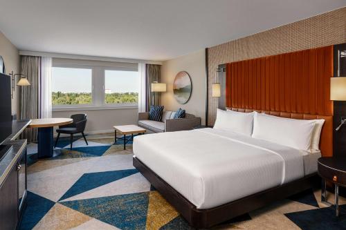 a bedroom with a large bed and a living room at Hilton Vienna Waterfront in Vienna