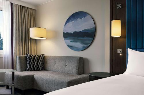 a hotel room with a bed and a chair and a mirror at Hilton Vienna Waterfront in Vienna
