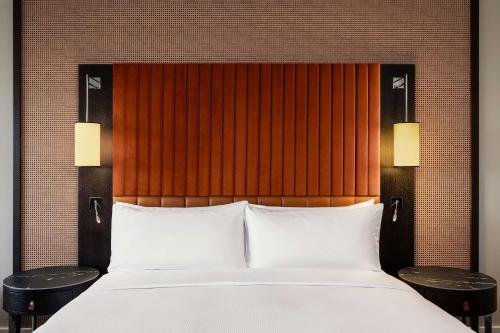 a bedroom with a bed with two tables and two lamps at Hilton Vienna Waterfront in Vienna