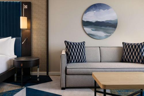 a living room with a couch and a bed at Hilton Vienna Waterfront in Vienna