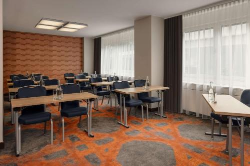 a conference room with tables and chairs and windows at Hilton Vienna Waterfront in Vienna