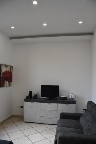 un salon avec un canapé et une télévision à écran plat dans l'établissement Central House, à Brindisi
