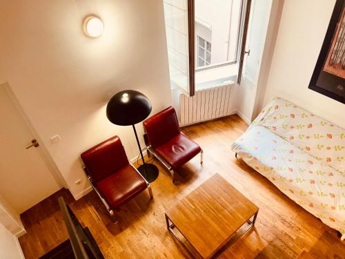 - une chambre avec deux chaises, un lit et une table dans l'établissement Le Calme de l’Opera., à Lyon