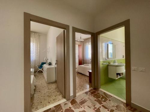 una habitación con un baño con lavabo y espejo en A Casa Di Mima, en Civitanova Marche