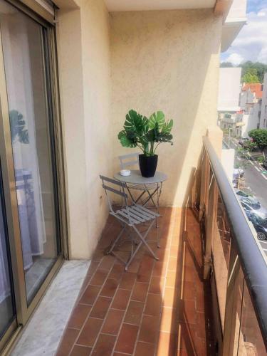 une petite table sur un balcon avec une plante en pot dans l'établissement STUDIO CENTRE VILLE avec PARKING PRIVATIF, à Cagnes-sur-Mer