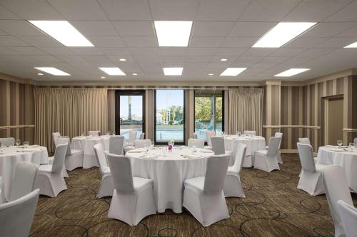 a conference room with white tables and white chairs at DoubleTree by Hilton Jacksonville Riverfront, FL in Jacksonville