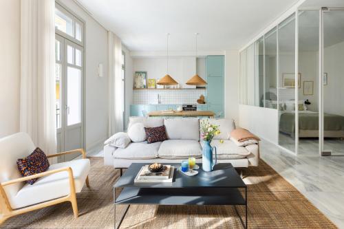 Una sala de estar con un sofá blanco y una mesa. en Silk n Cotton, en Atenas
