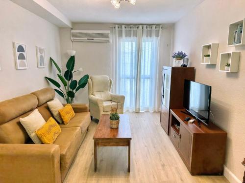 a living room with a couch and a tv at Apartamento Alcázar San Basilio in Córdoba