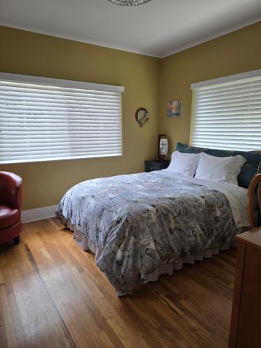a bedroom with a large bed and two windows at The Gingko House in Pasadena