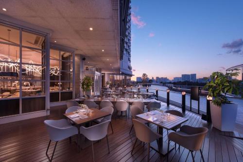 a restaurant with tables and chairs on a balcony at Hilton Tokyo Odaiba in Tokyo