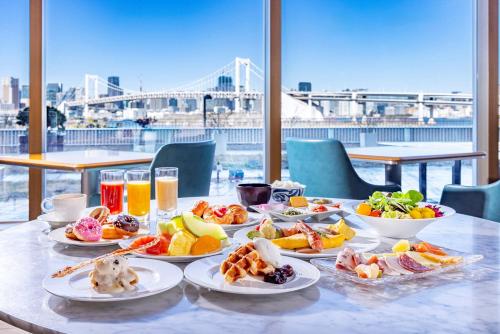 a table with plates of food and drinks on it at Hilton Tokyo Odaiba in Tokyo