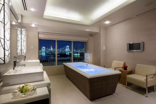 a bathroom with a tub and two sinks and a window at Hilton Tokyo Odaiba in Tokyo
