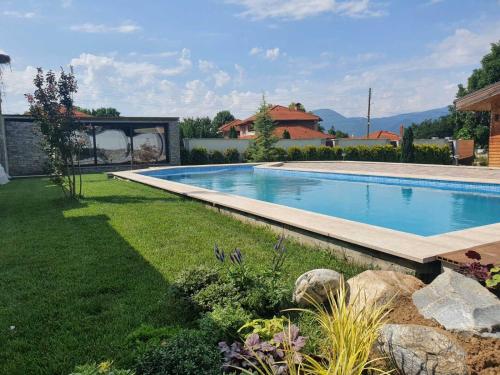 a large swimming pool in a yard with a grass yard at Vila Antik in Garmen