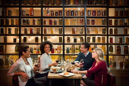 a group of people sitting around a table in a restaurant at The Logan Philadelphia, Curio Collection by Hilton in Philadelphia