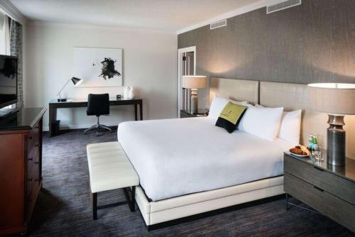 a hotel room with a large white bed and a desk at The Logan Philadelphia, Curio Collection by Hilton in Philadelphia