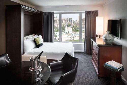 a hotel room with a bed and a table and chairs at The Logan Philadelphia, Curio Collection by Hilton in Philadelphia
