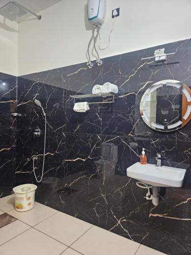 a bathroom with a sink and a mirror at Reverie Homestay in Kollam