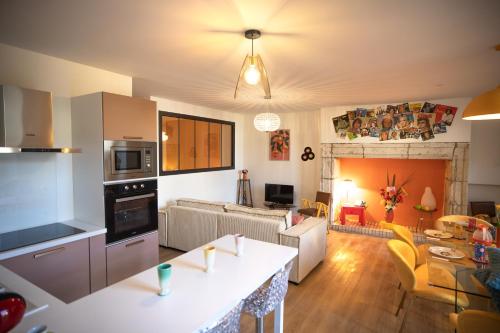 un salon avec une cuisine et un salon avec une table dans l'établissement Le Seventies & Spa Appartement spacieux et athypique, cœur du centre ville, à Agen