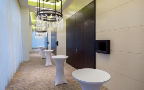 a row of white tables and stools in a hallway at DoubleTree By Hilton Moscow - Vnukovo Airport Hotel in Vnukovo