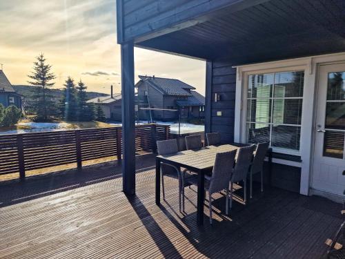 a wooden deck with a table and chairs on a house at Villa Tähkä - 12 henkilölle - HimosYkkösen alue - 116m2 in Jämsä