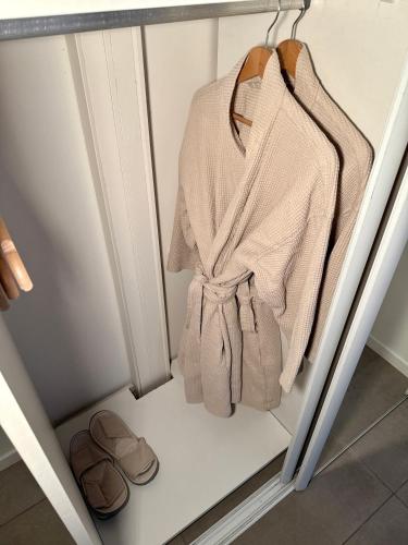 - un placard avec un peignoir, un porte-monnaie et des sandales dans l'établissement SPA JUNGLE, à Le Mesnil-Saint-Denis
