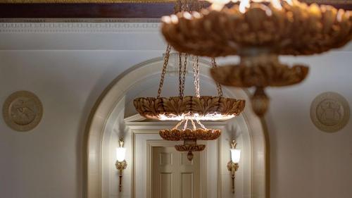 a chandelier in a hallway with a door at Amway Grand Plaza Hotel, Curio Collection by Hilton in Grand Rapids