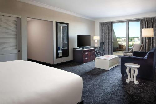 a hotel room with a bed and a couch and a television at Amway Grand Plaza Hotel, Curio Collection by Hilton in Grand Rapids