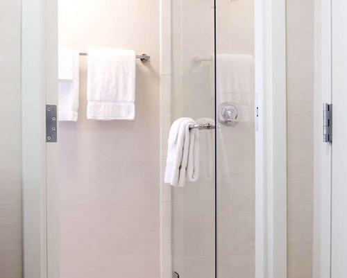 a bathroom with a shower with white towels at Hilton Orlando Buena Vista Palace - Disney Springs Area in Orlando