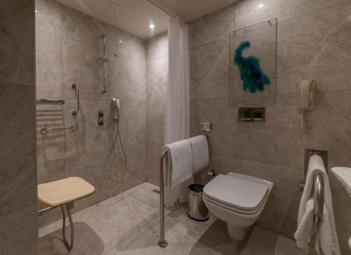 a bathroom with a shower and a toilet and a sink at DoubleTree by Hilton Istanbul - Sirkeci in Istanbul